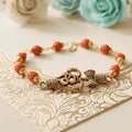 Om Rakhi bracelet with red rudraksha-style beads - om rakhi