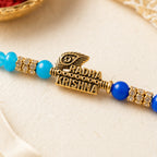 Close-up detail of blue Radha Krishna Rakhi bracelet charm and beads - rakhi for brother